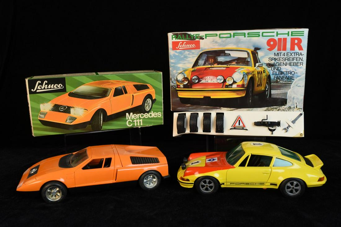 Schuco Mercedes C111 & Porsche 911 R: A pair of Schuco battery operated cars including a Mercedes C11 (5508) and a Porsche 911 R Rallye-Monte Carlo with decorative accessories. Both cars include their original packaging; functional moveme