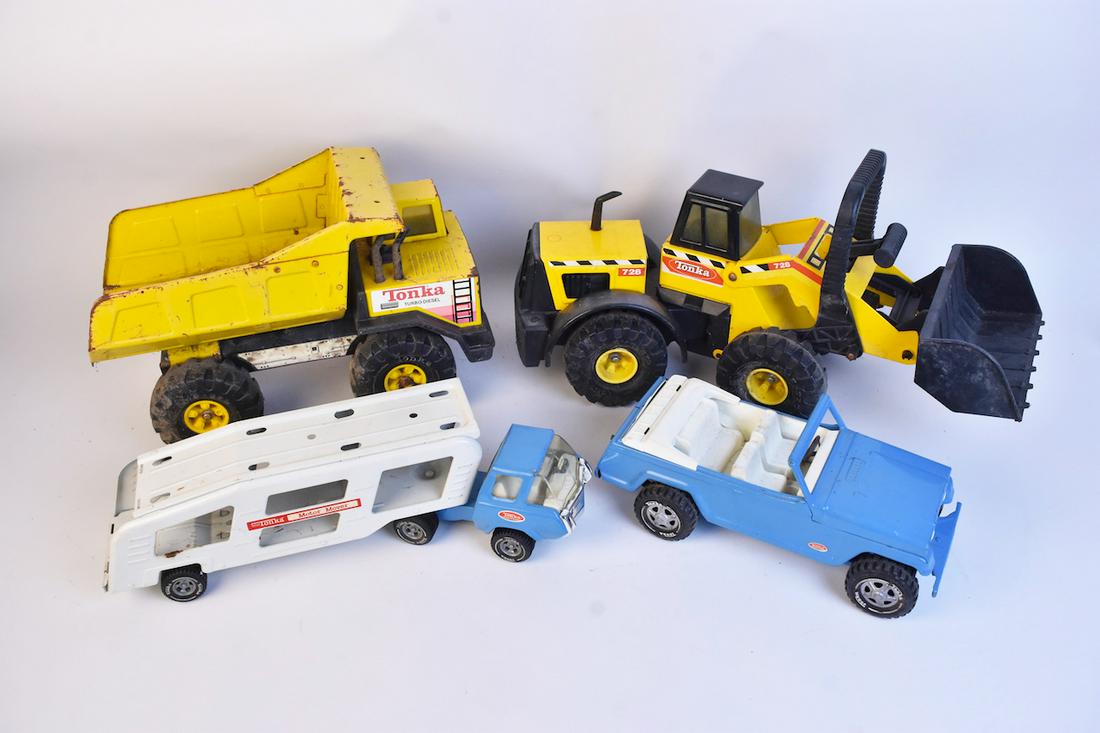 Vintage Tonka Pressed Steel Trucks: A selection of four vintage Tonka pressed steel toys dating to the 1970s and 80s. Includes a light blue Motor Mover; a 728 Mighty Front Loader; a baby blue Jeep; and a Turbo-Diesel dump truck. Heavy r