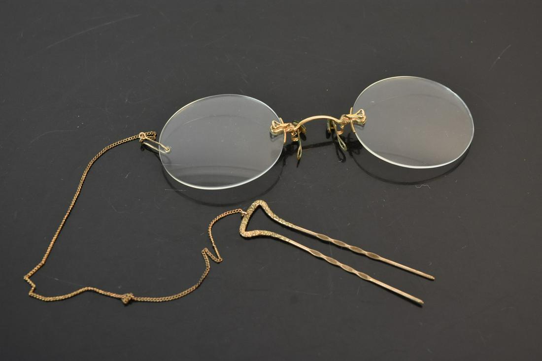 Vintage Prince Nez Eyeglasses: A pair of vintage Prince Nez style eyeglasses with a spring bridge and clip holder. Marked C & E. M. Co. at the bridge. There is a stubborn knot on the gold tone chain; some oxidation present at bridg