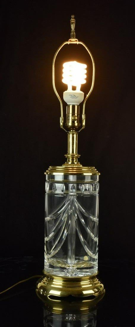 Waterford Crystal Table Lamp: A Waterford crystal table lamp measuring 27.5" H x 7.25" W x 5.5" D with harp. Light surface smudges to brass; lamp is functional. Please Note: Scheerer McCulloch Auctioneer only ships a limited numbe