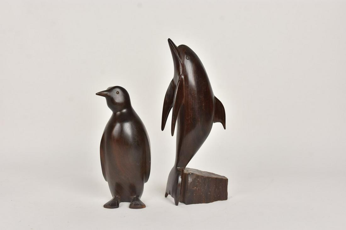 Hardwood Carved Penguin and Dolphin: A pair of carved hardwood statues of a dolphin and penguin. They feature a dark stain. No signature. Light surface scratches and markings. Dolphin measures approx. 12.25" H. Please Note: Scheerer McCu
