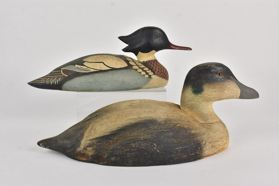 Carved Wood Duck Decoys: A pair of hand painted carved wood duck decoy figures. Unsigned. The largest measures approx. 6.75" H x 6.5" W x 18" D. Surface scratches and chipping; some loss of paint. Please Note: Scheerer McCull