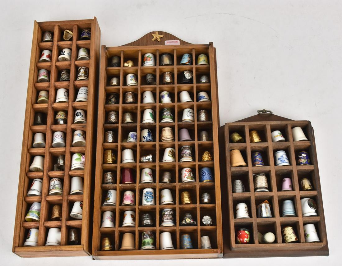 (3) Displays of Thimbles: 1" x ) 15" x 7.6" x 1.75" display case, has plastic clear cover and holds 50 thimbles, filled with ceramic, metal, painted, cloisonnŽ thimbles, (1) 15.25" x 4.25" x 1.75" display case, plastic cover 