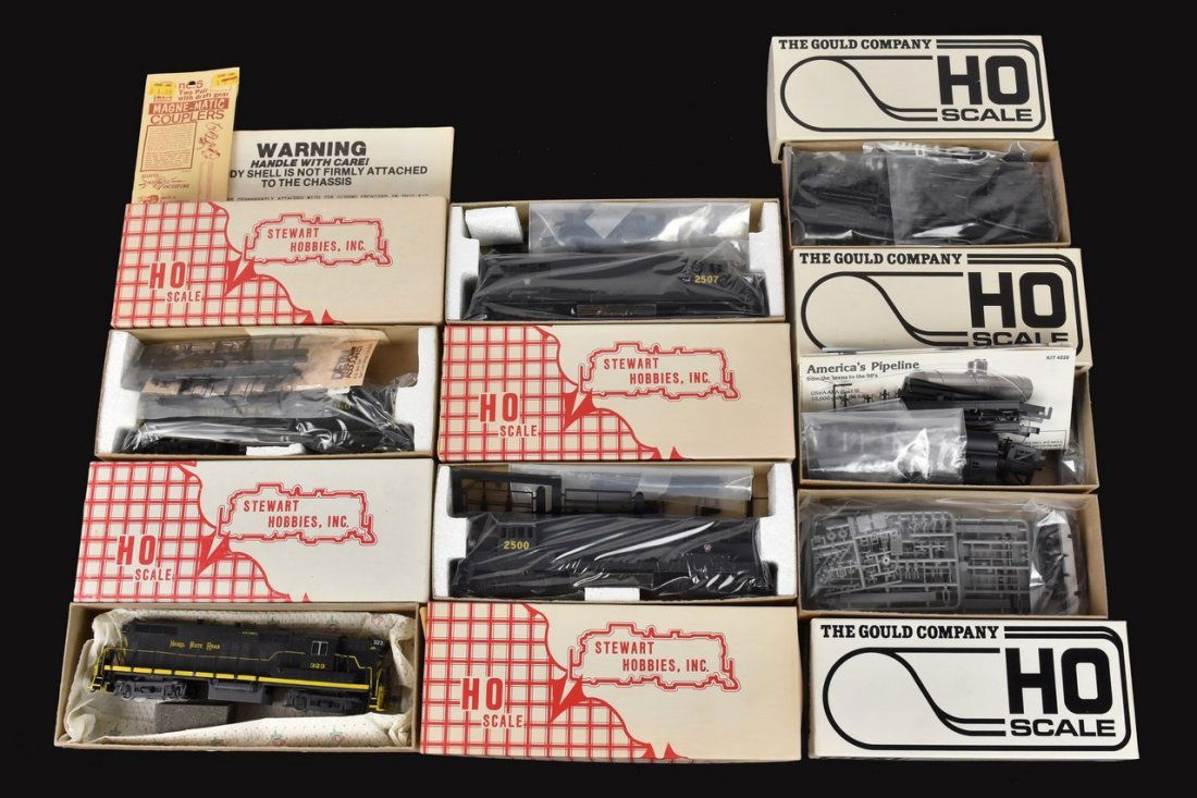 (7) HO Scale Model Train Kits: A collection of seven HO scale model train kits in original packaging including Stewart Hobbies and The Gould Company. Includes boom car, steam wrecking crane, tank car, and more. Contents of packagin