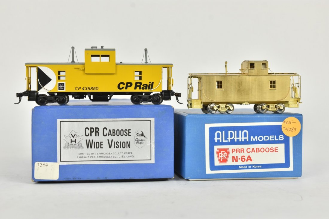 (2) Brass HO Scale Cabooses: A pair of brass HO scale trains in original packaging. Includes an Alpha Models PRR Caboose N-6A; and VH Scale Models crafted by Samhongsa Co. of Korea CPR Caboose w/ Wide Vision. Light shelf wear to 