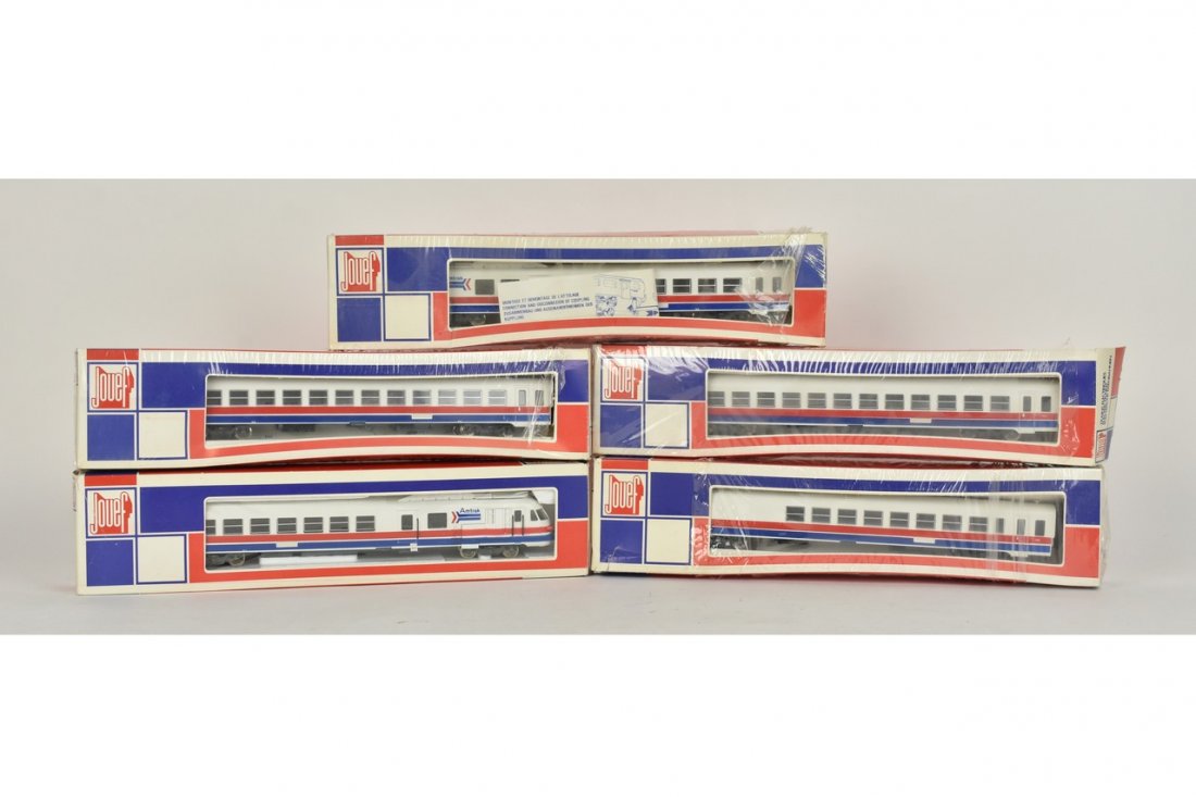 (5) Jouef HO Scale Amtrak Train Cars: A set of five Jouef HO scale Amtrak train cars in original packaging. Includes 5894, 5893, 8998, and 5892x2. Crushing and shelf wear to packaging. Please Note: Scheerer McCulloch Auctioneer will add s