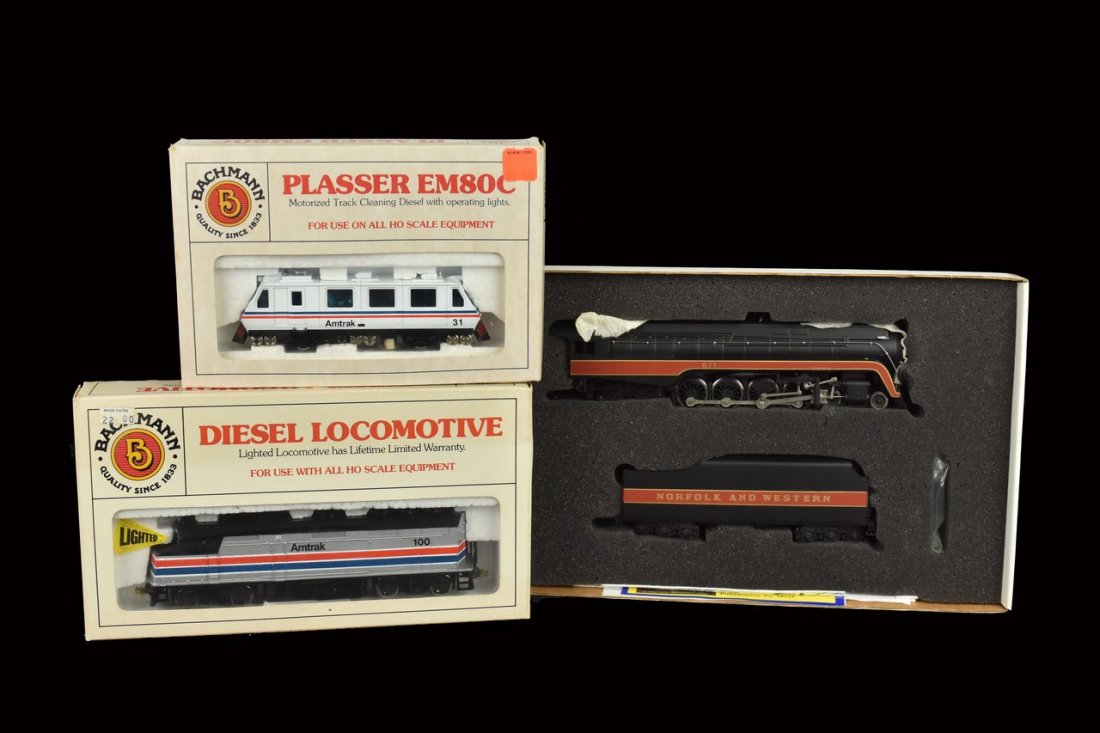 (3) Bachmann HO Scale Trains: A collection of three HO scale Bachmann trains in original packaging. Includes a Plasser EM80C; an Amtrak Diesel Locomotive; and a Class J 4-8-4 locomotive w/ tender. Light shelf wear to packaging; re