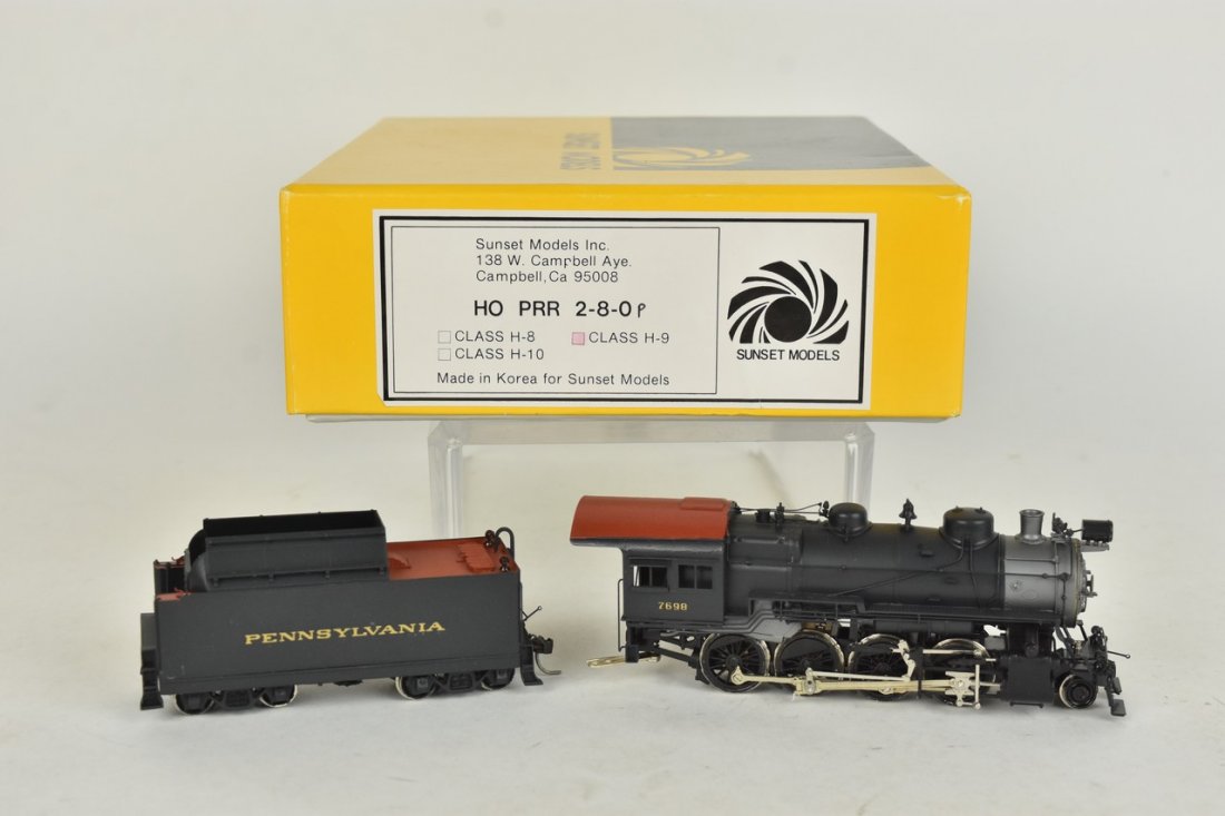 Sunset Models Brass PRR Locomotive & Tender: An HO scale Sunset Models painted brass H-9 Pennsylvania Railroad 2-8-0 locomotive with tender. In original packaging with light shelf wear. Please Note: Scheerer McCulloch Auctioneer will add shippin
