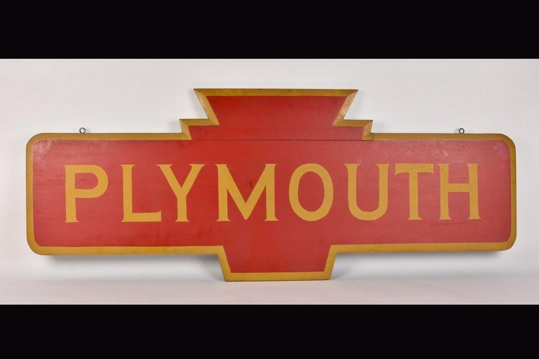 Plymouth Wooden Sign: A wood sign that reads "Plymouth" with a keystone figure at its center. This sign likely refers to a Plymouth train station depot in either Indiana or Michigan. It measures approx. 61" W x 24" W x 2" 