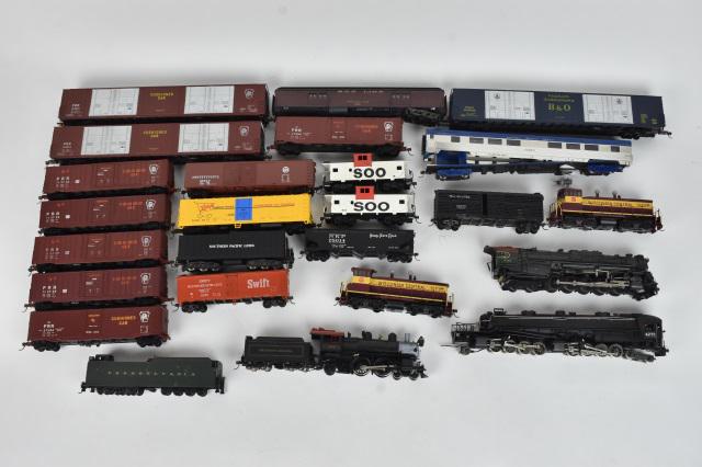 Over 20 HO Scale Train Cars: A collection of over 20 HO scale plastic train cars; most unmarked. One locomotive marked Mantua. Condition varies- some are missing wheels/couplers; surface scratches; loss of paint; all untested. Pl
