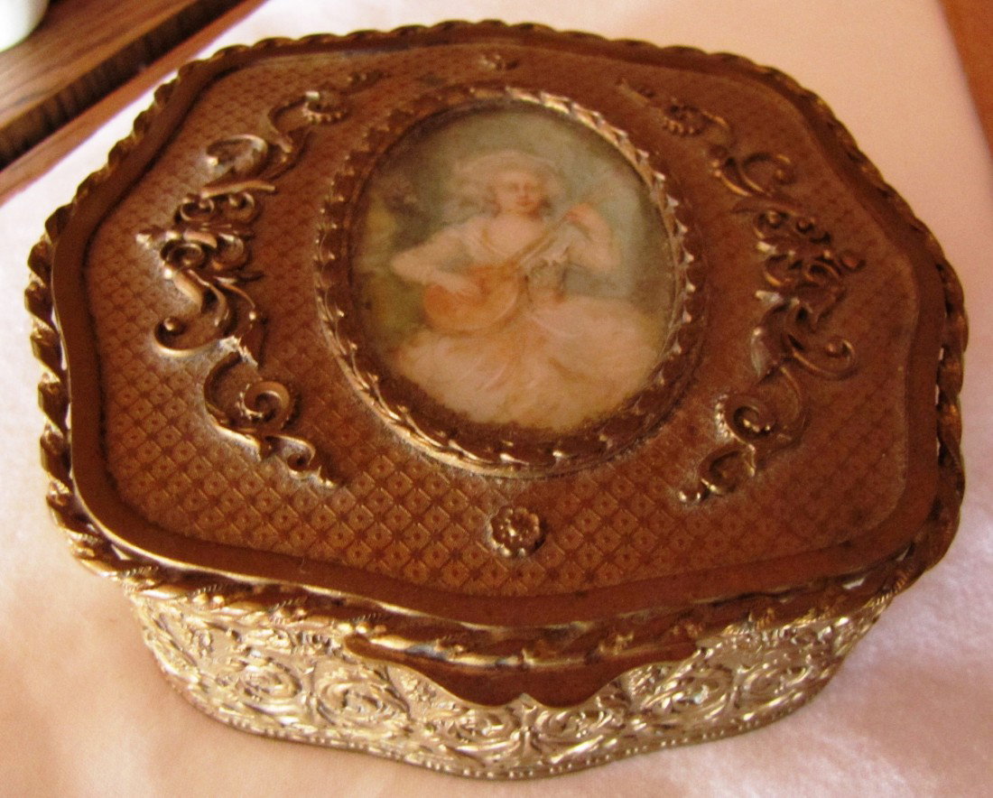 Pair of Antique Metal Dresser Boxes: (Left pictured) Hinged metal box with cloth lining and lady playing musical instrument insert. (Right pictured)Oval box measuring 4 1/4" x 3 1/8".