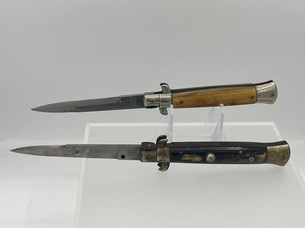 Lot of 2 -INOX and A& K Switchblade Knives: INOX switch blade has Buffalo horn handle. Push button (knif) with sliding lock stiletto in working order. Makers mark on blade as well as manufacturer. Knife measures approx. 8 3/4 inches open with 4