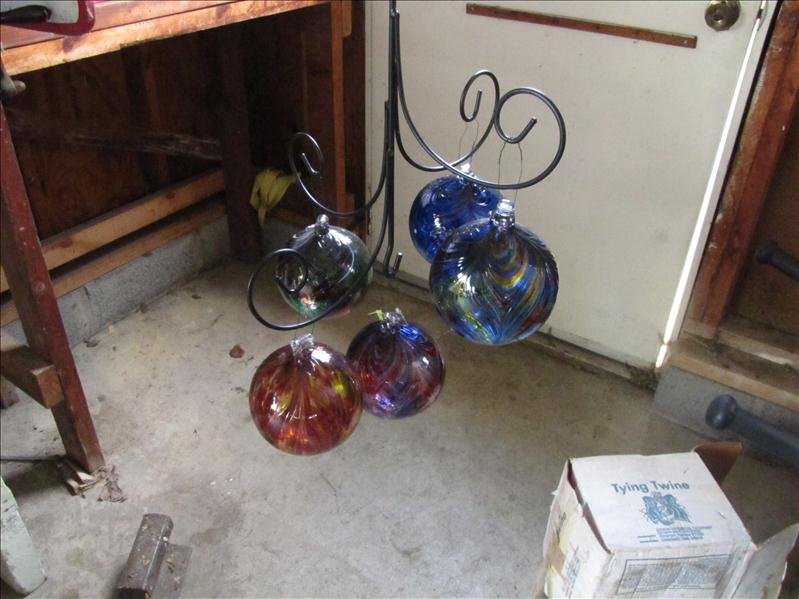 Hanging glass yard display: Hanging glass yard display. (5) Glass spheres hanging from iron hook. 16" circumference. Decorative yard art.
