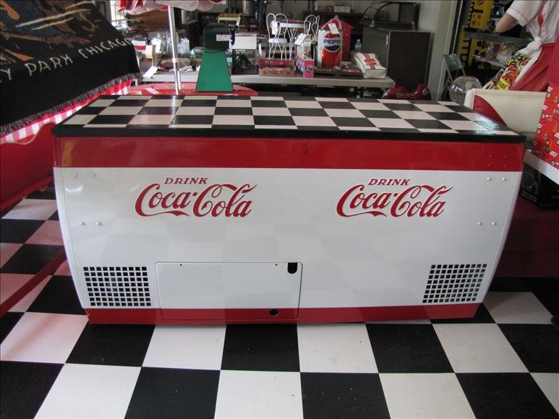Large Drink Coca Cola Cooler: Large Drink Coca Cola Cooler This is a very large chest cooler with Coca Cola logos on each side. This is insulated. There is no compressor for this piece but could be used with ice. The top is custom