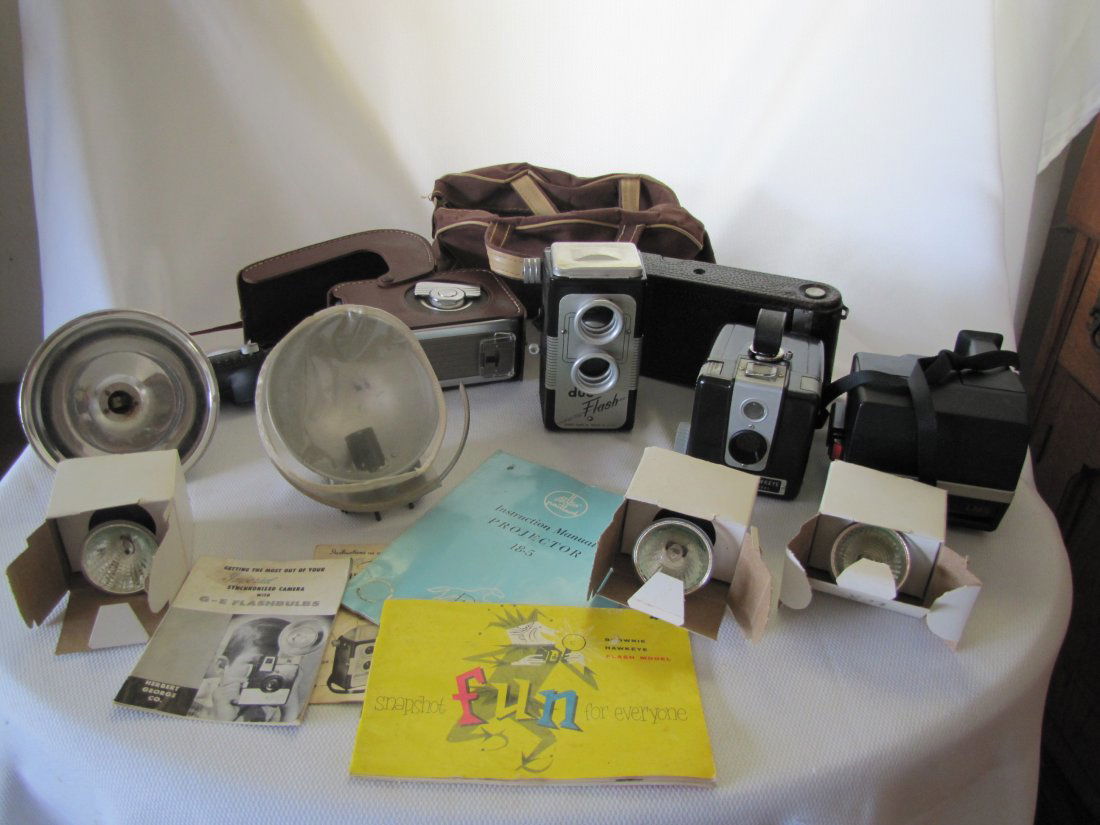 Vintage Cameras & Equipment: Lot of Vintage Cameras & Equipment This lot includes manuals for cameras, projectors and flashbulbs, bulbs, flashes and assorted cameras. The cameras include Polaroid Sun 66, Kodak Brownie Hawkeye, Ko