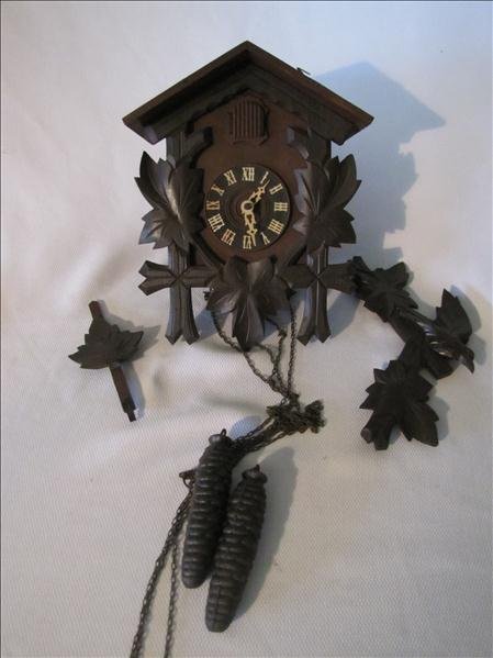 Antique German Cuckoo Clock: Antique German Cuckoo Clock This clock is solid wood with ornate carved accents. This comes complete with two pine cone shaped weights. The clock measures 8" x 10.5" x 5.5".