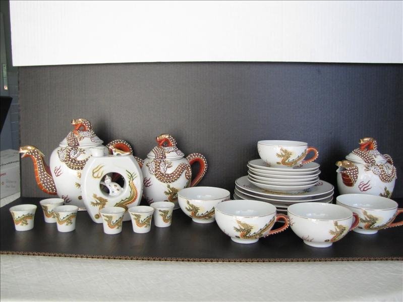 Ornate Japanese Dragon Sake, Tea, & Desert Set: Ornate Japanese Dragon Sake, Tea, & Desert Set. China made in Japan. Very unique and decorative dragon motif on china set. Teapot is 9.5" wide and 8" tall. The sugar and creamer are 7.5" wide and 6" t
