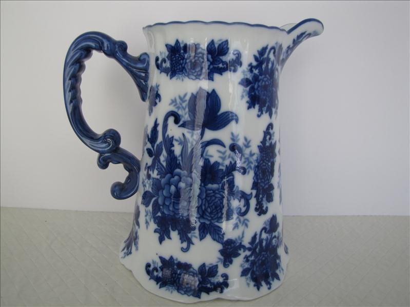 Flow Blue Water Pitcher: Flow Blue Water Pitcher. Marked "CB" on the bottom of the pitcher. Pitcher measures 7" in width at the base and 9" tall. 6.5" wide handle to spout and 5" opening.