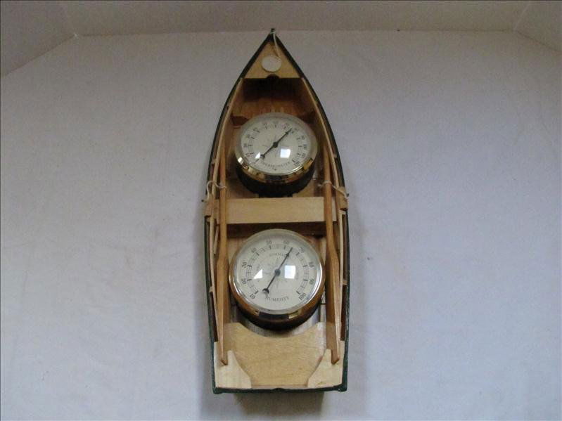 Thermometer and Humidity Gauge In Boat Case: Thermometer and Humidity Gauge In Boat Case A decorative wooden boat wall hanging with thermometer and humidity gauge. Measures 15.5" long and 5" wide. Very good condition.