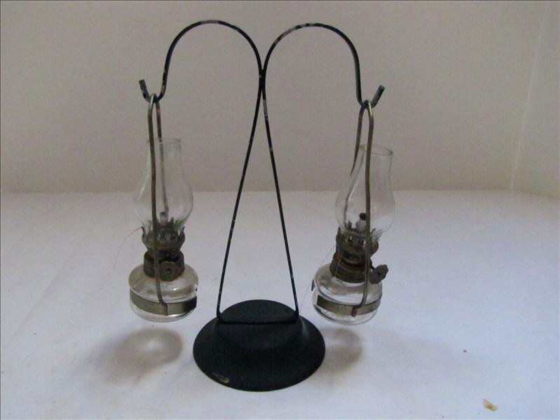 Two Miniature Oil Lamps on Hanger: Two Miniature Oil Lamps on Hanger 7" tall and about 5.5" wide. Oil lamps are 3.75" tall. Paint is chipping a little on the hanger. Overall good condition.