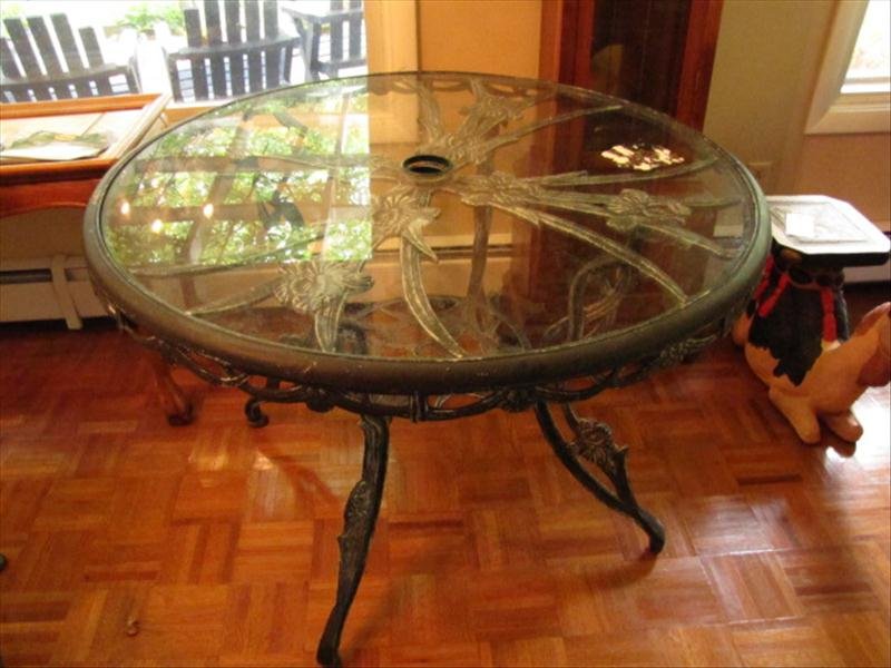 Metal & Glass Patio Umbrella Table: Metal & Glass Patio Umbrella Table Iris flower design metal frame work for the table base. Table has round glass top. Glass top and base have holes to hold an umbrella. Table measures 42" in diameter.