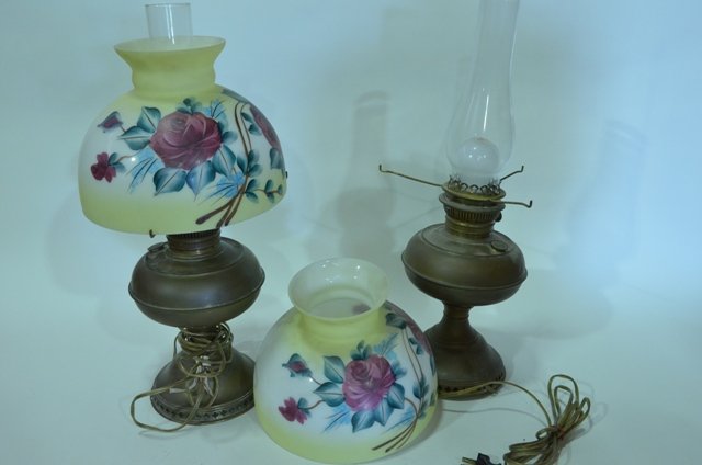(2) Rayo Oil Lamps w/ Chimney & Shade Electrified: Lot of two Rayo Oil Lamps with matching chimneys and shades. Both lamps are electric. Shades are yellow in color and depict a floral scene. With chimney, lamps measure 20.5" tall and shades are 10" in