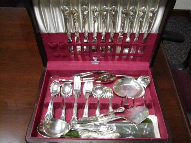 Set of Sterling Silver Flatware in Chest: This large set of sterling silverware comes in a wooden felted chest. The total weight of the serling silver flatware and serving pieces that are entirely sterling in construction is 76.85ozt. There a