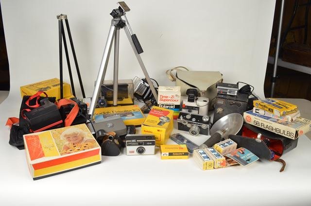 Large Lot of Vintage Camera Equipment: This lot includes several pieces of camera equipment including vintage cameras, tripods, flashbulbs, Poloroid film and so much more. Among this lot are such things as a Poloroid Swinger Model 20 Land 