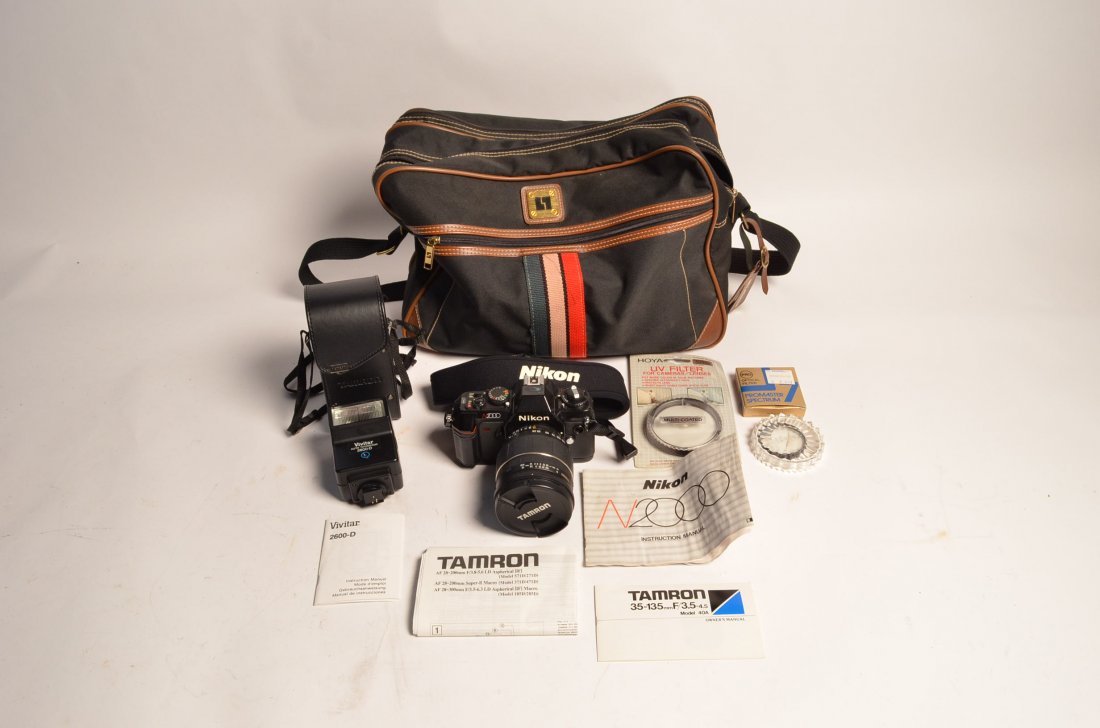 Photography Equipment Nikon N2000 Camera: This lot consists of a Nikon N2000 camera with a Tamron model 40A 35~135mm lens, a Vivitar 2600-D detachable flash, carrying case and more. Also included is a Promaster Spectrum optical filter and a H