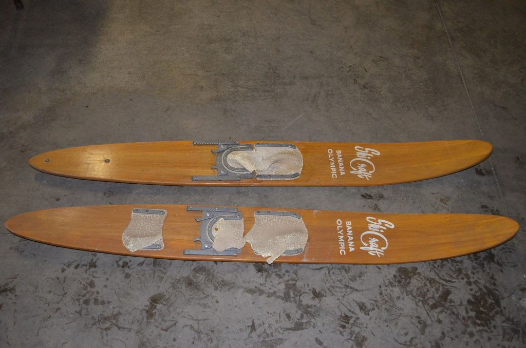 Ski Craft Wooden Water Skis: A pair of vintage wooden skis by Ski Craft. Banana Olympic. Skis measure 60" long and 7" wide at the widest point. The fins do not match, one is wood and the other is metal and deeper. Rubber boots ar