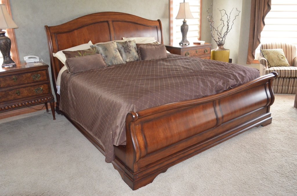 King Size Mahogany Sleigh Bed W/ Bedding: Sleigh appears to be cherry or mahogany wood and is very well constructed. Bed comes complete with box springs, mattress, pillows, accent pillow, shams, coverlet, and sheets. Mahogany sleigh bed is we