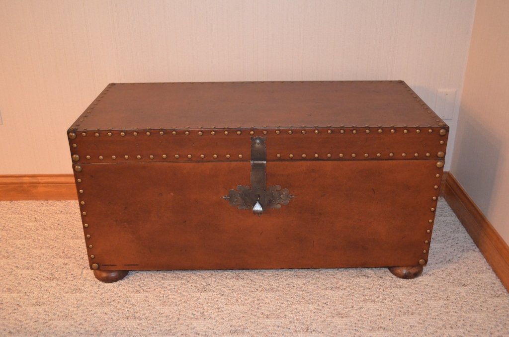 Leather Toy Chest: Brass tack accents, iron handles, and wooden round feet. Toy trunk has latch. Contents not included. Measures 39" W X 18" D X 19" H.