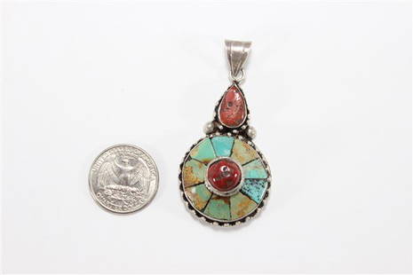 Sterling Silver Turqoise and Coral Pendant: Elaborate silver work with inlayed turqoise and coral pendant. Two and a half inches long. Approx. 13 grams.