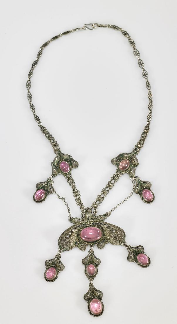 Silver & Pink Tourmaline Cabochon Necklace: Finely detailed silver necklace; featuring nine pink tourmaline cabochons of ovoid form, with largest centered horizontally; Provenance: Collection of Joel Emmanuel; L: 10 1/2" (approx.)
