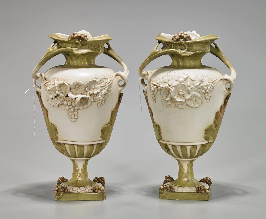 Pair Art Nouveau Ceramic Grapevine Vases: Pair of Art Nouveau ceramic vases; each of ovoid form with flared rim resembling grapevine; showing floral design in high relief and slim foot leading to square base; Royal Dux Bohemia mark to base; H