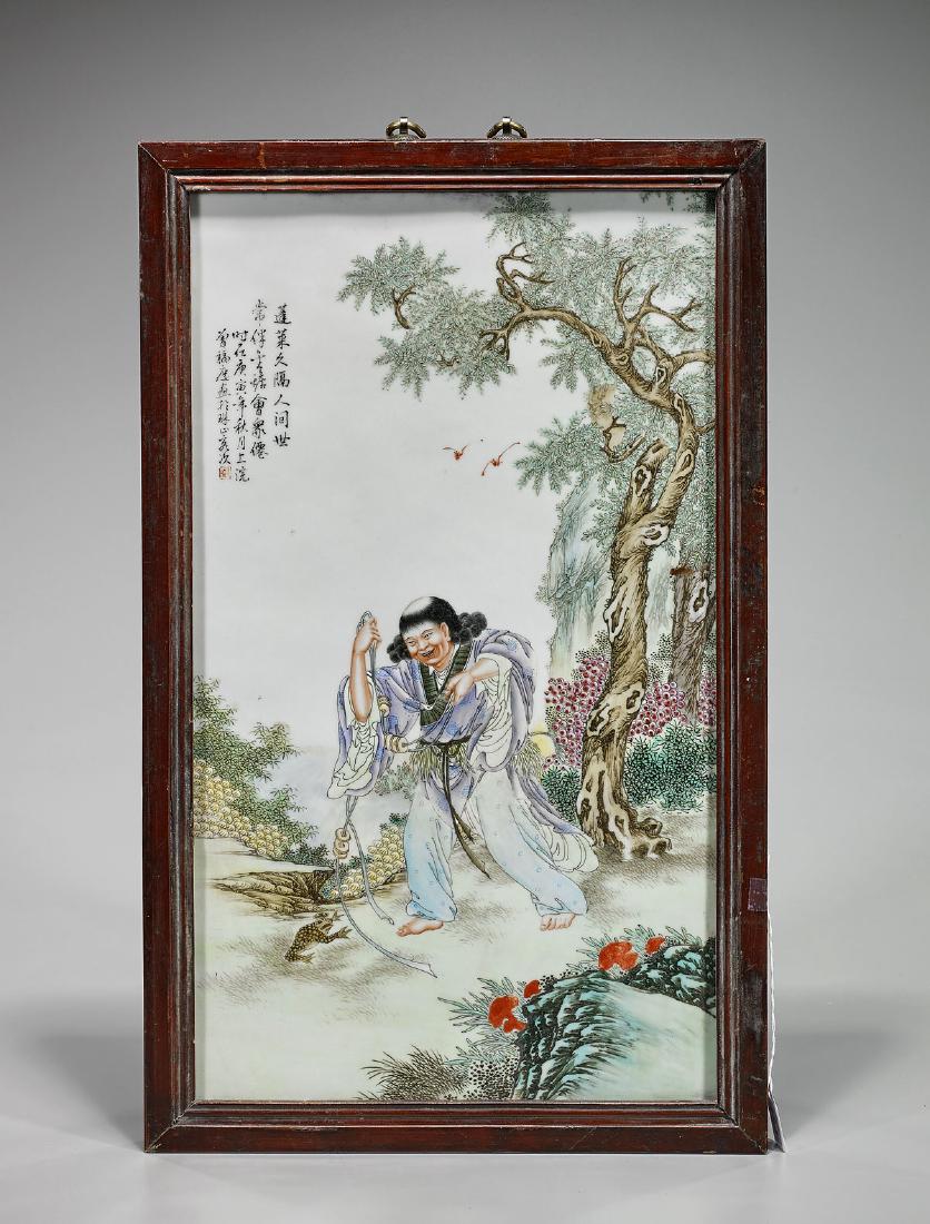 Chinese Famille Rose Enameled Porcelain Plaque: Chinese Famille Rose enameled porcelain plaque; depicting a figure carrying a string of coins, strolling barefoot through a forested landscape; inscribed, with seal mark; 20 5/8" x 12" (si