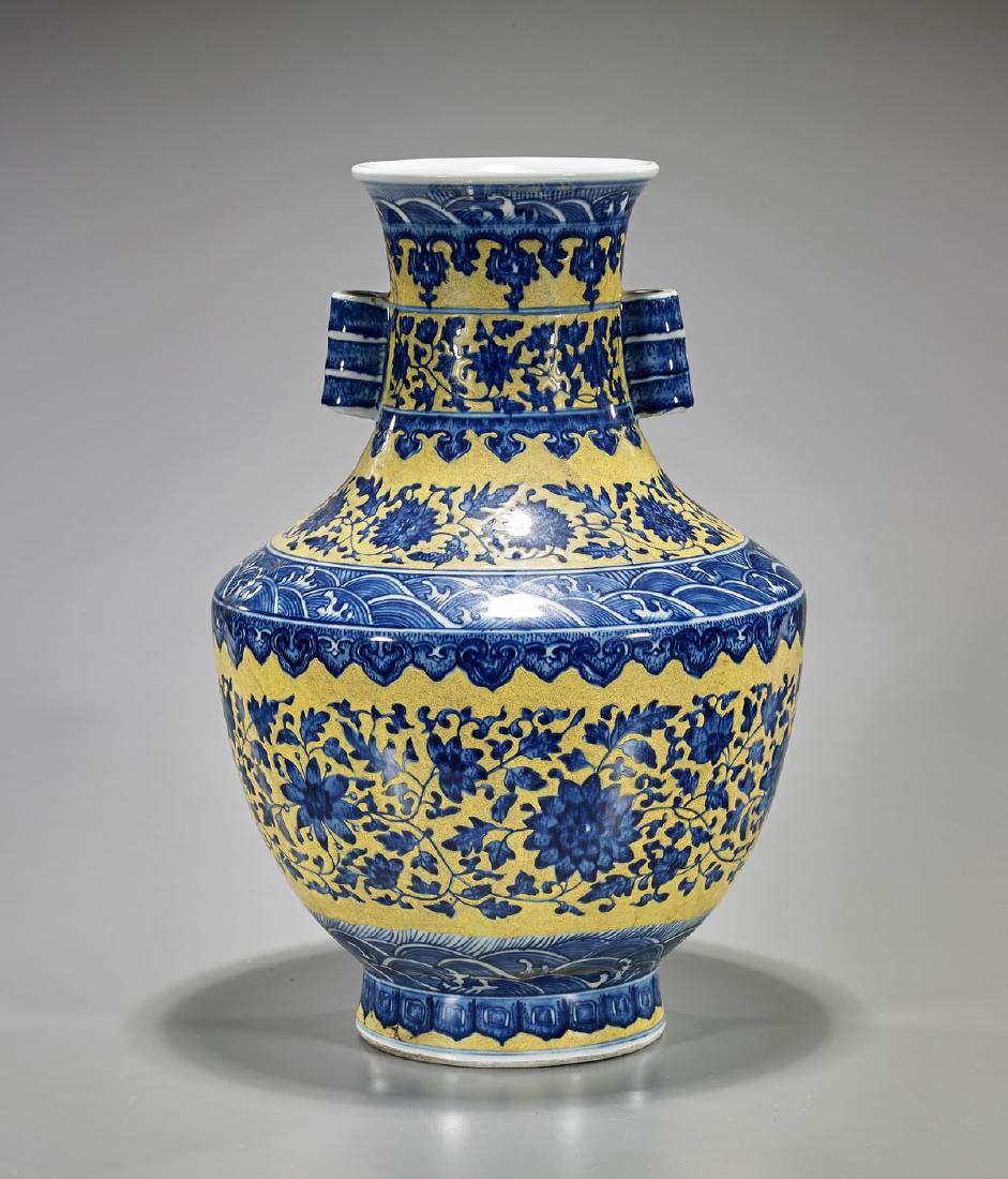 Old Qianlong-Style Porcelain Vase: Old Chinese Qianlong-style blue and white porcelain vase; of baluster form, with two moulded bamboo-form handles and featuring a bright yellow overglaze; showing various scrolling flora and fauna to s