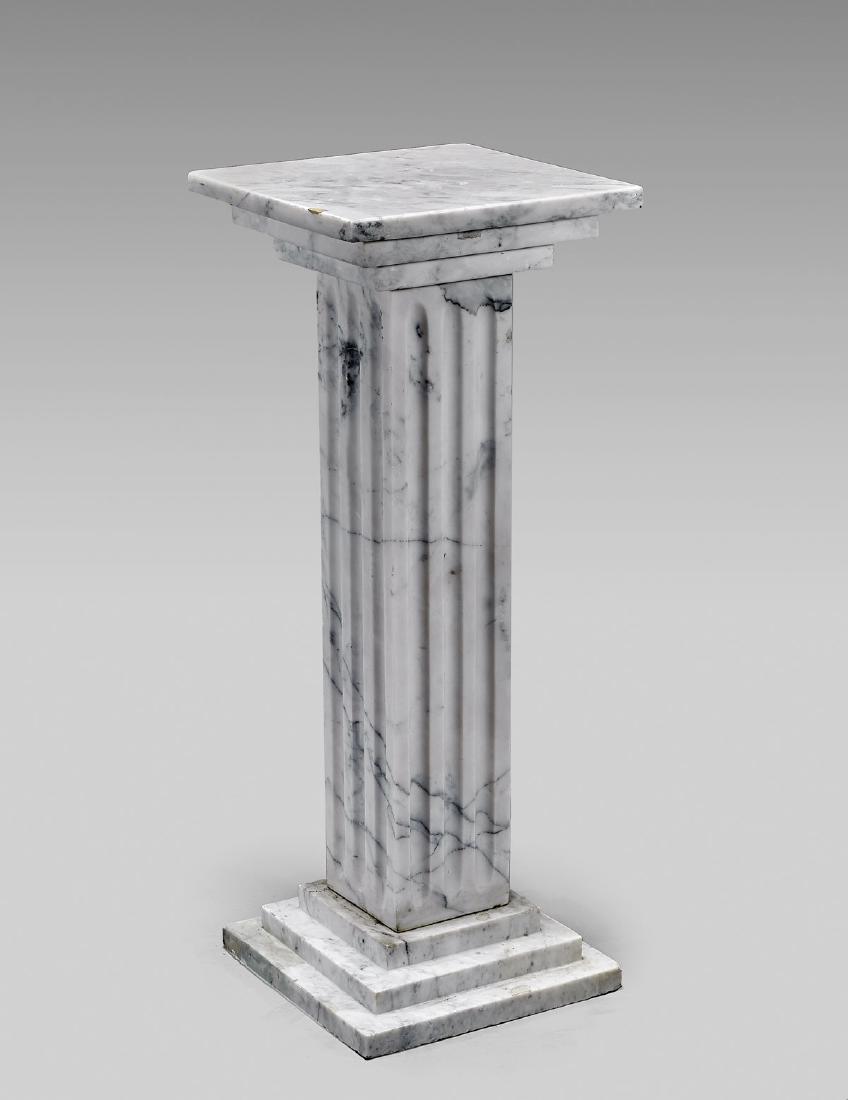 MARBLE COLUMN PEDESTAL: Marble column pedestal; the squared, fluted body upon and surmounted by a stepped base and top; the stone showing dark grey veins; Provenance: Collection of Eugene Iglesias; H: 35 3/4"