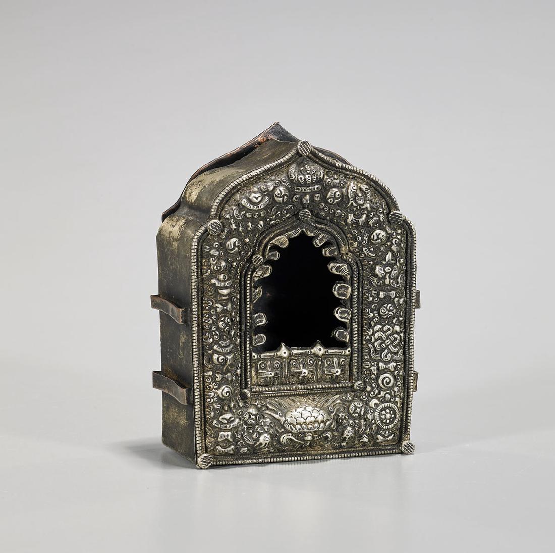 Antique Tibetan Silver-Toned Metal Shrine: Antique Tibetan silver-toned metal shrine; with repoussé detailing of various flora and Buddhist symbols; with incised linear motif to verso; H: 5 3/8" (approx.)