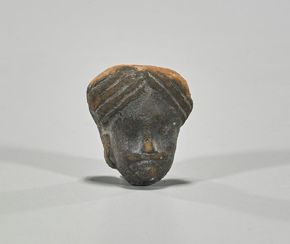 Small Gandharan Pottery Head of a Man: Small Gandharan pottery head of a man; with moulded and incised detailing to head-covering and face; Provenance: Collection of Stuart H. Salsbury; L: 1 5/8" (approx.)