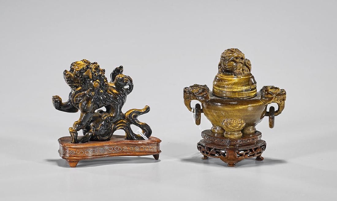 Two Chinese Tiger Eye Carvings: Two Chinese tiger eye carvings, including: Fo lion standing atop a sphere; together with tripod censer, set upon a tripod base with dragon handles pending loose rings with Fo lion finial; W: 3 1/2"