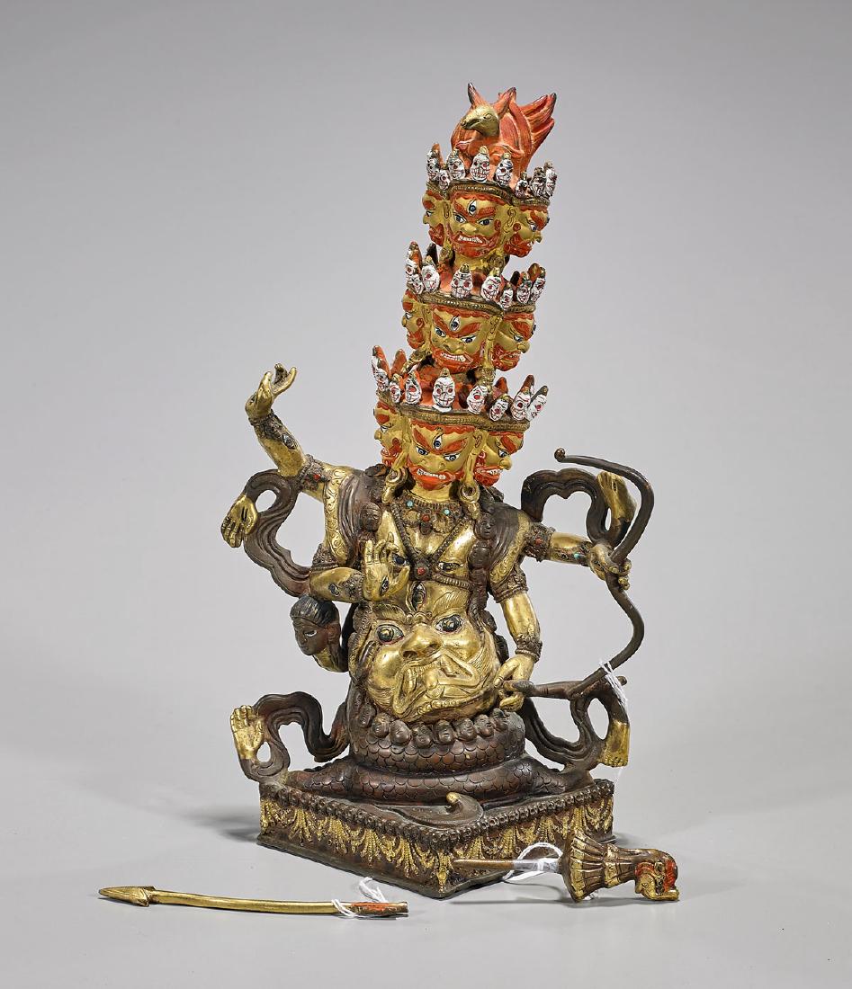 Sino-Tibetan Gilt Bronze Figure of a Deity: Sino-Tibetan gilt bronze figure of a wrathful deity; of anthropomorphic form; his stacked headdress comprised of many faces; set upon a squared base, with incised mark to base together with gilt arrow