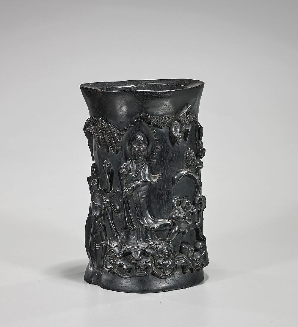 Chinese Carved Hardwood Brushpot: Chinese carved hardwood brushpot; exhibiting a Guanyin, pouring out her bottle of tears; with a child attendant beside her; both together on a lotus pad atop stylized waves amid various pond flora and