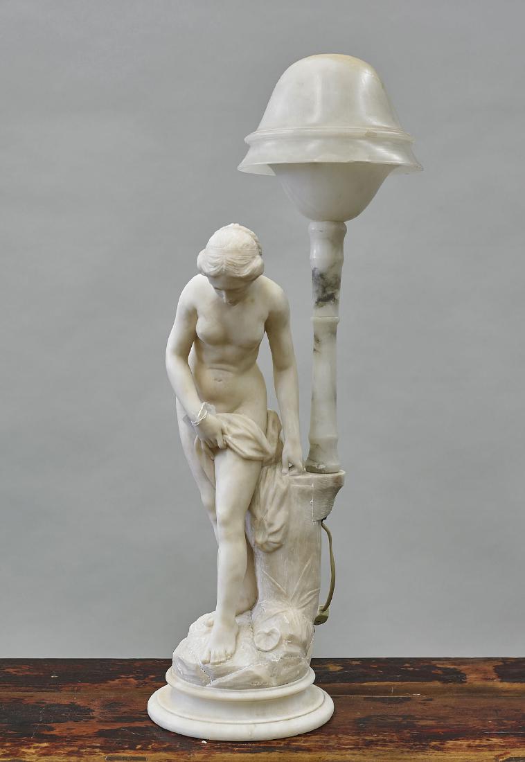 Carved Alabaster Figural Lamp: Carved alabaster figural lamp; exhibiting a partially nude beauty, gazing downwards; her dress set atop a rectangular base, supporting a covered dome-form, featuring one light socket within; signed G.