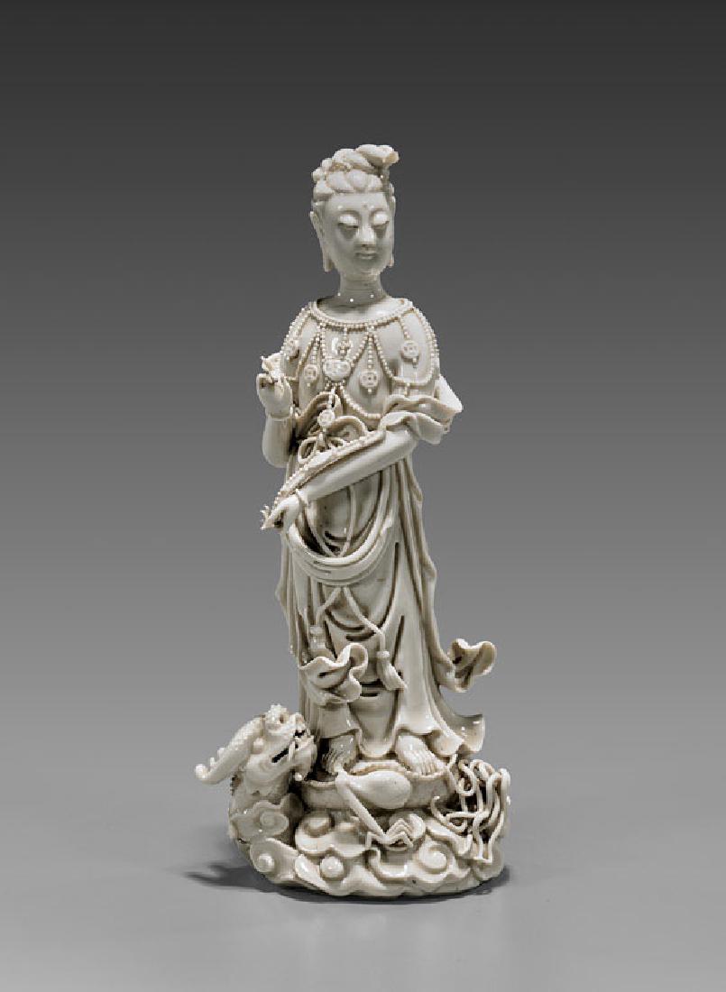 Antique Blanc De Chine Guanyin: Antique and elaborately modeled, Chinese blanc de chine porcelain figure; of Guanyin dressed in flowing robes, and ornately adorned in beaded garlands, holding a scepter and standing atop a writhing d