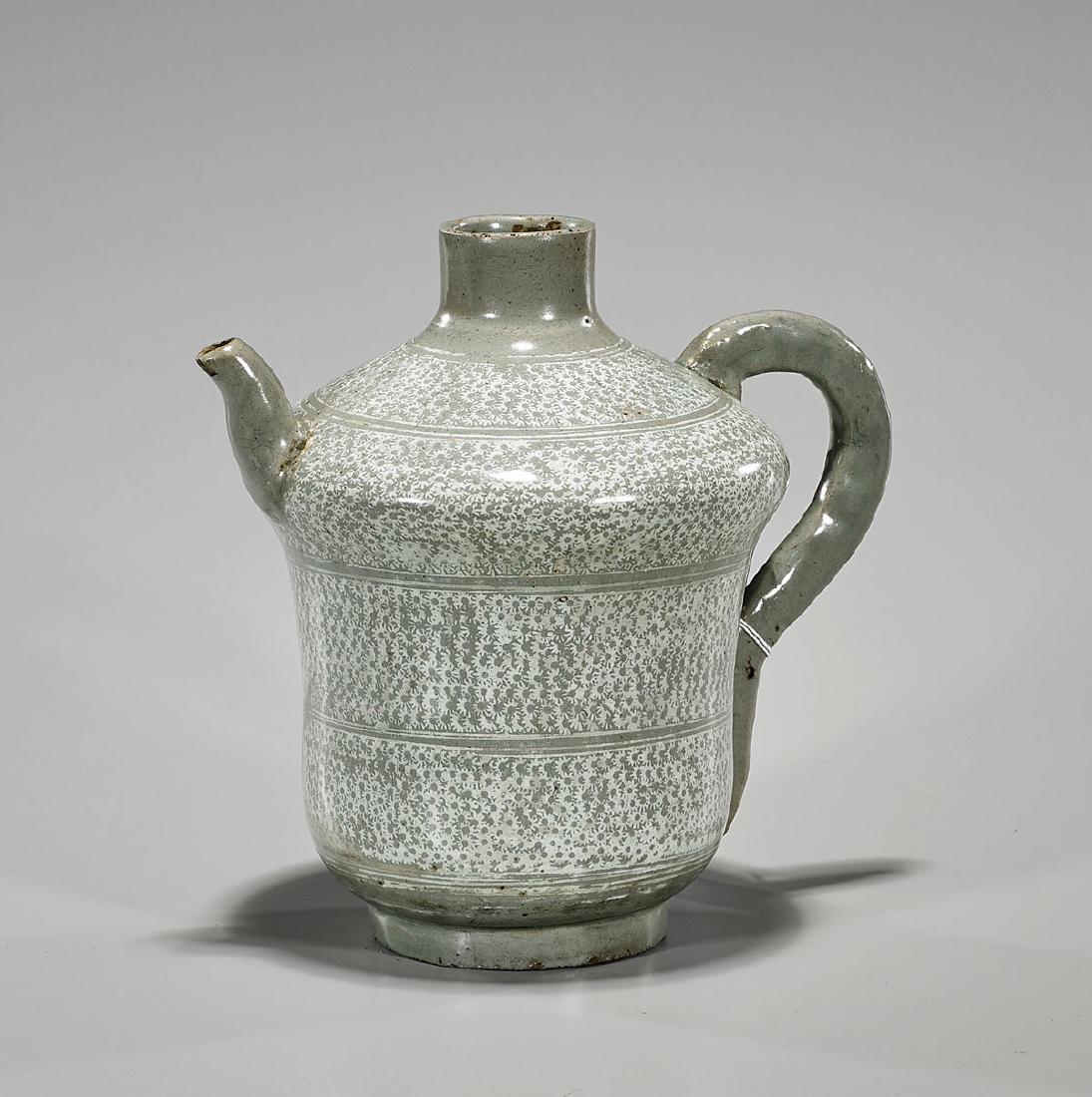 Antique Joseon Dynasty Buncheong Ewer: Antique Korean Joseon Dynasty buncheong ewer, with moulded handle and spout; showing dense floral designs between concentric bands throughout body; H: 8" approx.