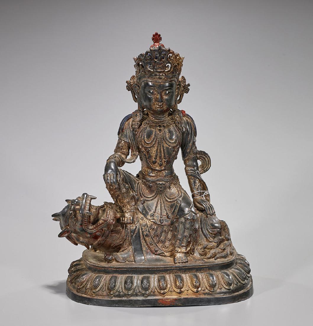 Chinese Bronze Seated Guanyin: Chinese Song-style bronze Guanyin; adorned in elaborately detailed crown, garlands and robe; seated in position of 'royal ease' upon a recumbent lion; all atop a lotus base H: 20" approx.