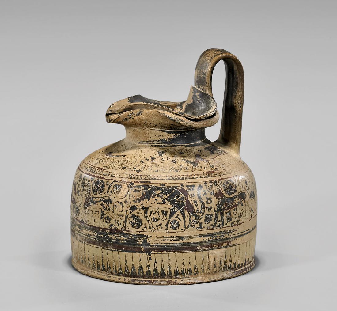 CORINTHIAN BLACK-FIGURE TREFOIL OINOCHOE: Greek Corinthian black-figure trefoil oinochoe; the central register with a kneeling male figure holding a spear, amid striding lions and ibexes; the upper register centering a pair of seated sphinxes