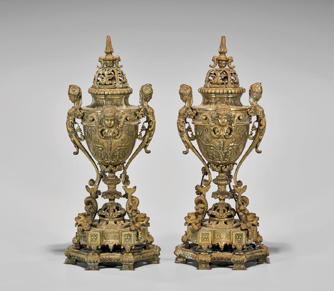 PAIR FRENCH GILT BRONZE PERFUME BURNERS: Pair of French gilt bronze perfume burners; each urn flanked by female caryatid handles and putti masks above draped fruit garlands; upon an elaborate tiered base surmounted by a fish at each side; wi
