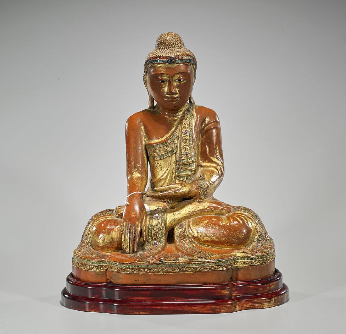Antique Thai Parcel-Gilt & Lacquered Wood Buddha: Antique Thai parcel-gilt and lacquered wood Buddha; the gesturing hands with elongated fingers in mudra; wearing elaborate 'jeweled' robe; showing typical extended ears and snail-curled hair; 